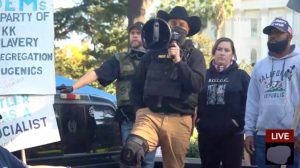 Christopher Young speaks with Jeffrey Perrine (left) and Alicia Peterson (right) behind him